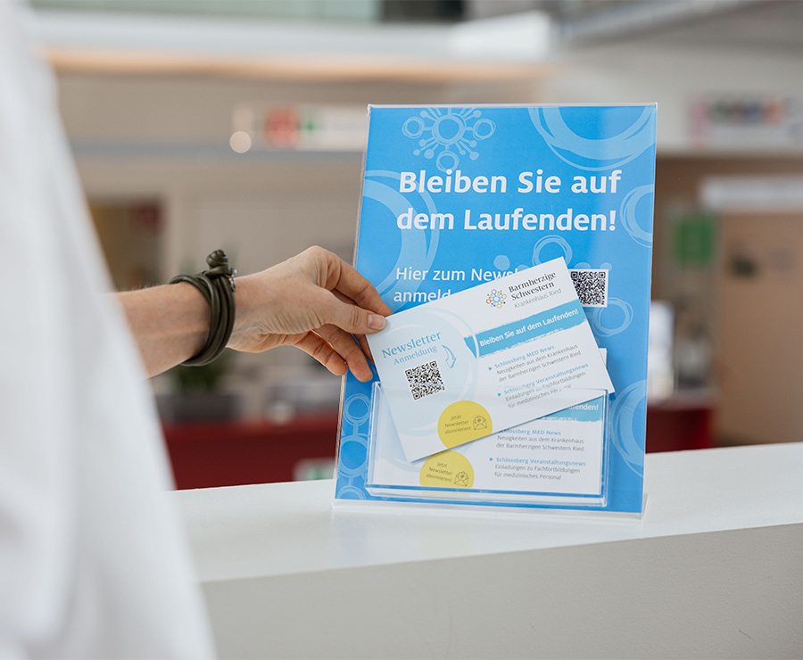Person entnimmt Infoblatt zur Newsletter-Anmeldung