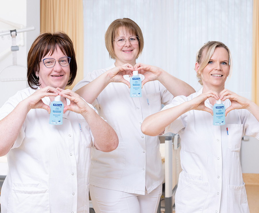 Pflegemitarbeiterinnen mit Desinfektionsgelen in der Hand