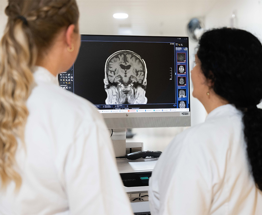 Eine Neurologin und Pflegekraft besprechen eine MR-Aufnahme