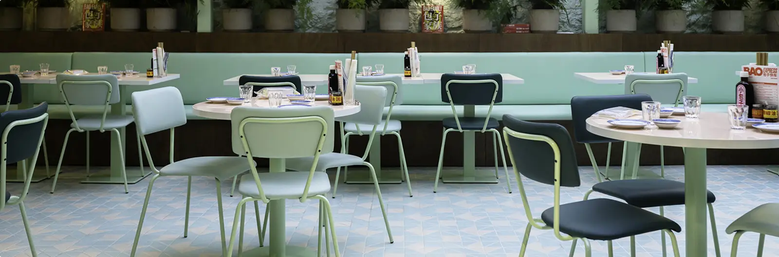 Cafe interior with green dining chairs and tables
