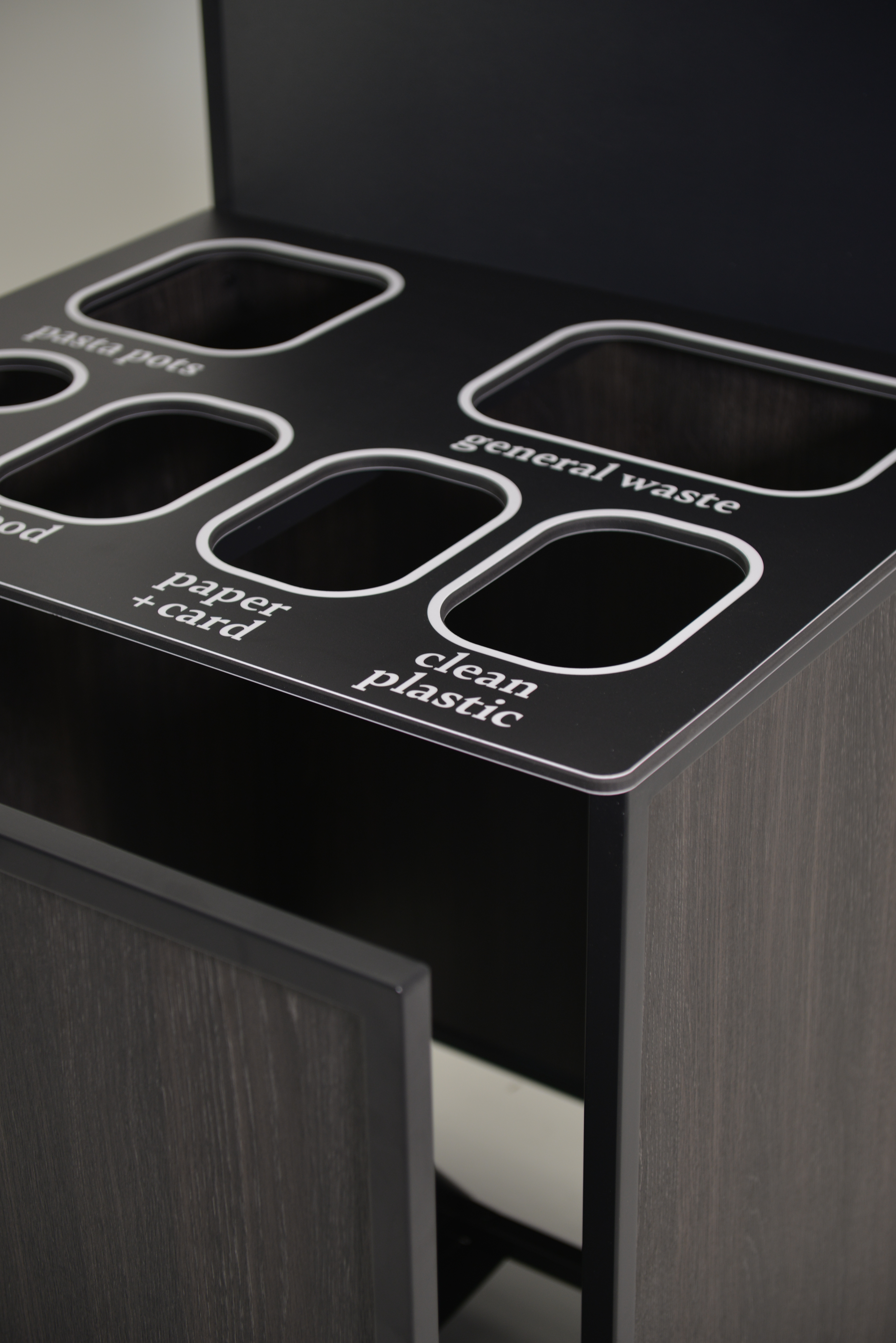 Close-up of labelled recycling station openings