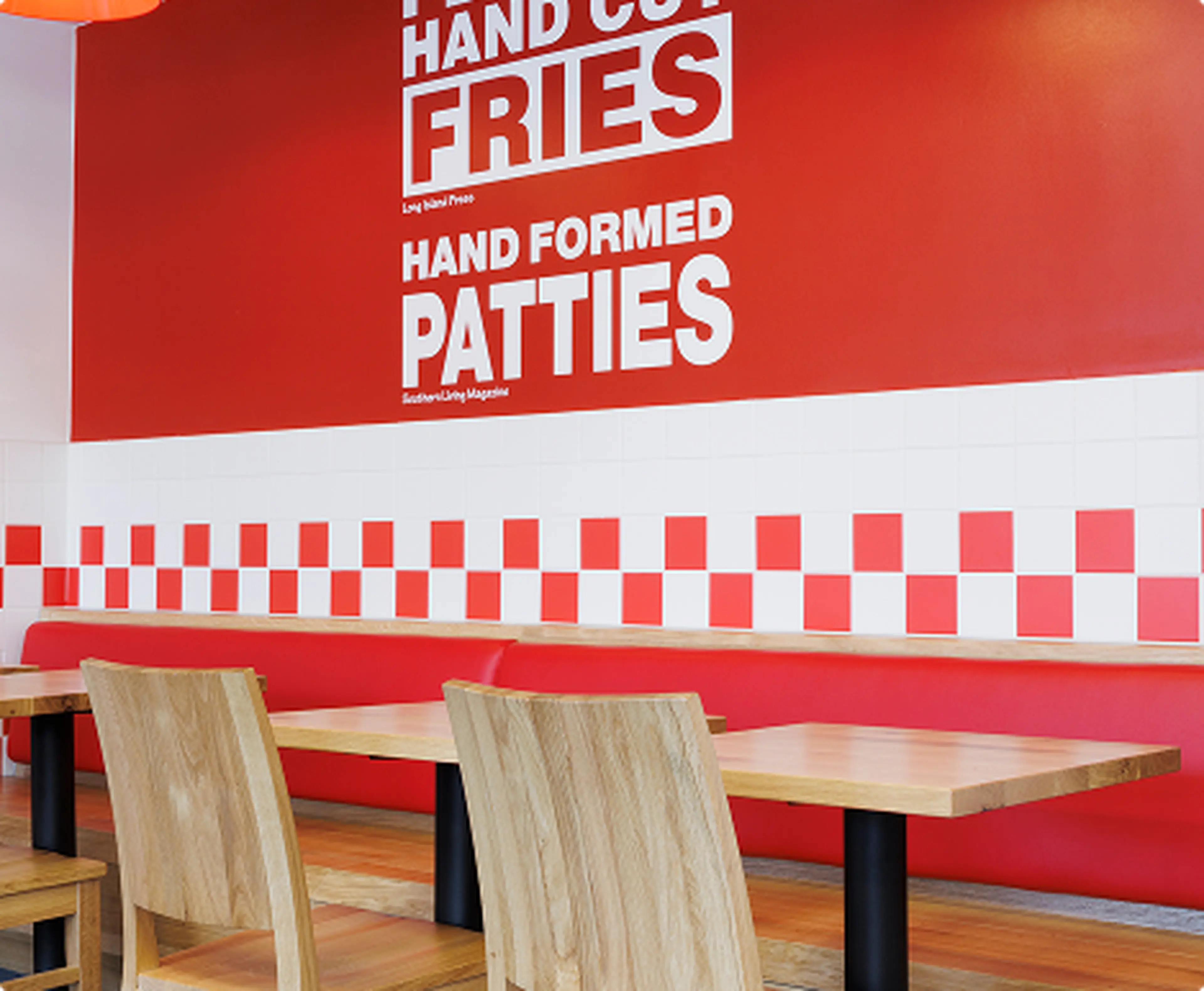 Timber dining chairs beside red upholstered restaurant seating