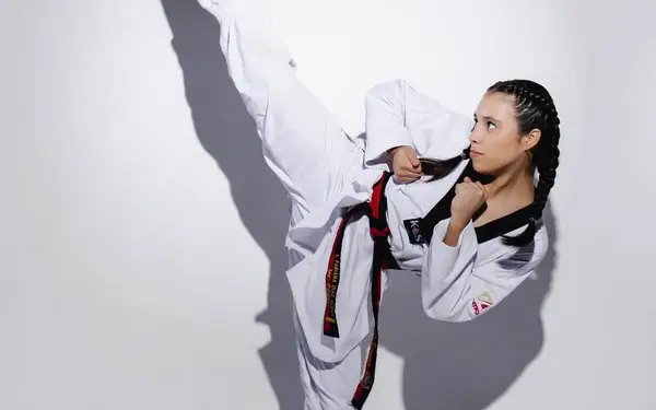 Alumna adulta de Taekwondo ejecutando patada alta en Cumbres