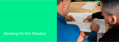 Foto von zwei Personen die sich einen Plan anschauen und beraten.