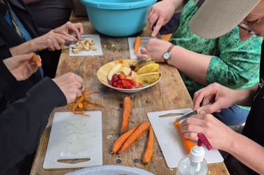 Menschen bei der Schnippeldisko schneiden Gemüse und Obst
