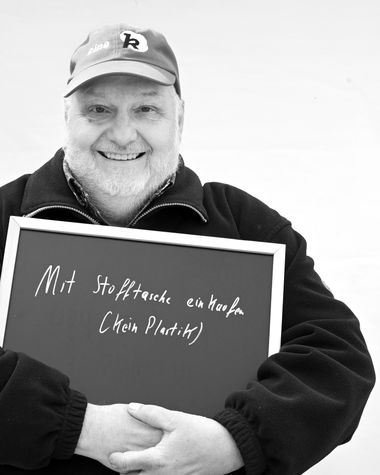 Eine Person aus Oldenburg zeigt ein Schild auf dem steht „Mit Stofftasche einkaufen (kein Plastik)“ Foto: Jörg Hemmen