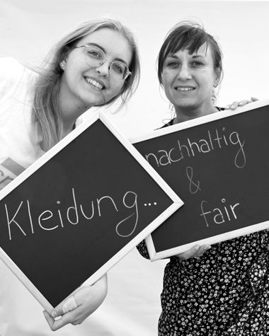 Zwei Personen aus Oldenburg zeigen ein Schild auf dem steht „Kleidung...nachhaltig und fair“ Foto: Jörg Hemmen