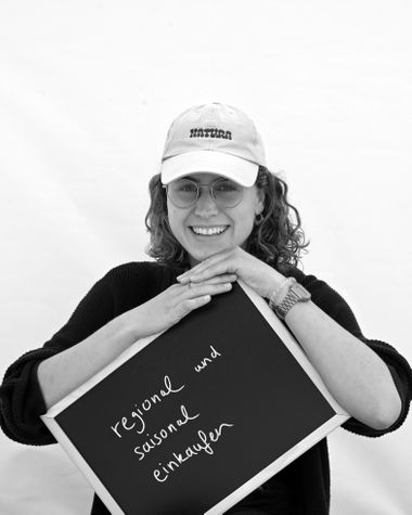 Eine Person aus Oldenburg zeigt ein Schild auf dem steht „regional und saisonal einkaufen“ Foto: Jörg Hemmen
