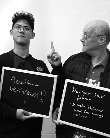 Zwei Personen aus Oldenburg zeigen ein Schild auf dem steht „Fleischkonsum verringern. Weniger SUV fahren - mehr Fahrrad und Carsharing nutzen“ Foto: Jörg Hemmen