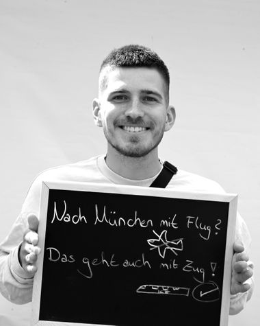 Eine Person aus Oldenburg zeigt ein Schild auf dem steht „Nach Münschen mit Flug? Das geht auch mit dem Zug!“ Foto: Jörg Hemmen