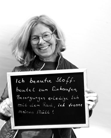 Eine Person aus Oldenburg zeigt ein Schild auf dem steht „Ich benutze Stoffbeutel zum Einkaufen, Besorgungen erledige ich mit dem Rad, ich trenne meinen Müll“ Foto: Jörg Hemmen