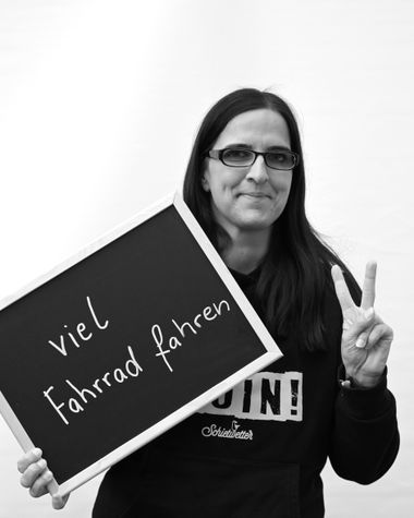 Eine Person aus Oldenburg zeigt ein Schild auf dem steht „viel Fahrrad fahren“ Foto: Jörg Hemmen