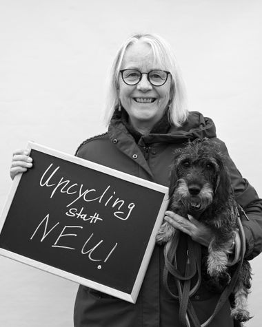 Eine Person aus Oldenburg zeigt ein Schild auf dem steht „Upcycling statt neu!“ Foto: Jörg Hemmen