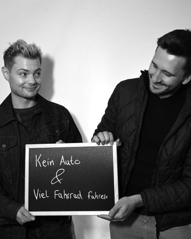 Zwei Personen aus Oldenburg zeigen ein Schild auf dem steht „Kein Auto und viel Fahrrad fahren“ Foto: Jörg Hemmen