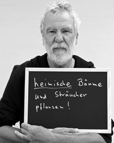 Eine Person aus Oldenburg zeigt ein Schild auf dem steht „heimische Bäume und Sträucher pflanzen!“ Foto: Jörg Hemmen