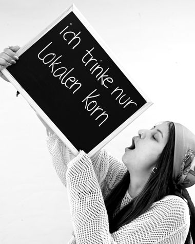 Eine Person aus Oldenburg zeigt ein Schild auf dem steht „Ich trinke nur lokalen Korn“ Foto: Jörg Hemmen