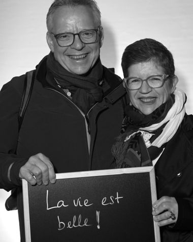 Zwei Personen aus Oldenburg zeigen ein Schild auf dem steht „La vie est belle!“ Foto: Jörg Hemmen