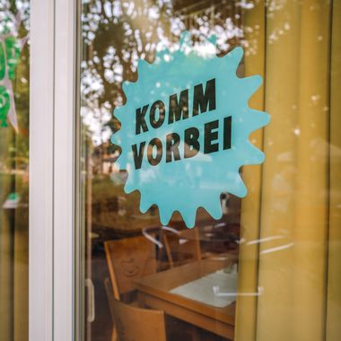 „Komm vorbei “-Schild in einem Fenster