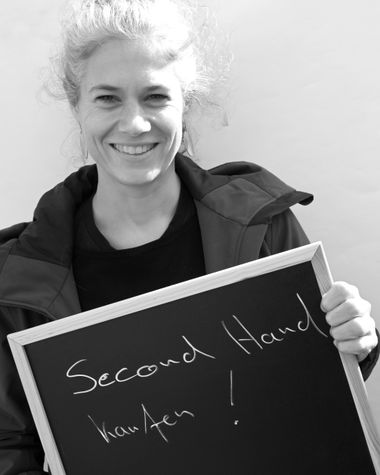 Eine Person aus Oldenburg zeigt ein Schild auf dem steht „Second Hand kaufen!“ Foto: Jörg Hemmen