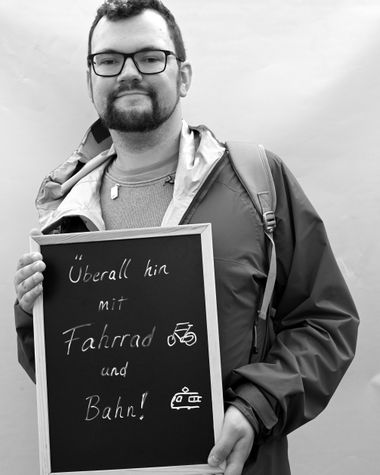 Eine Person aus Oldenburg zeigt ein Schild auf dem steht „Überall hin mit Fahrrad und Bahn!“ Foto: Jörg Hemmen