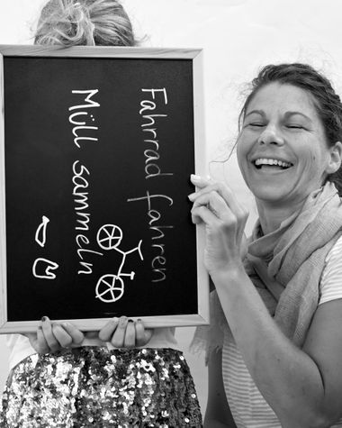 Zwei Personen aus Oldenburg zeigen ein Schild auf dem steht „Fahrrad fahren, Müll sammeln“ Foto: Jörg Hemmen