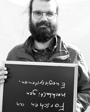 Eine Person aus Oldenburg zeigt ein Schild auf dem steht „Forschen an nachhaltigen Energiesystemen“ Foto: Jörg Hemmen