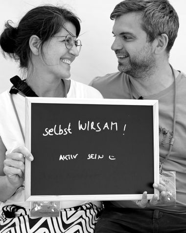 Zwei Personen aus Oldenburg zeigen ein Schild auf dem steht „selbst WIRSAM! Aktiv sein“ Foto: Jörg Hemmen