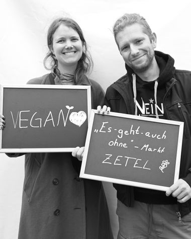 Zwei Personen aus Oldenburg zeigen ein Schild auf dem steht „vegan und "Es geht auch Ohne"-Markt Zetel" Foto: Jörg Hemmen