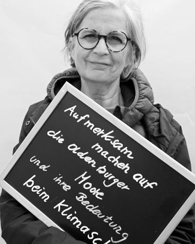 Eine Person aus Oldenburg zeigt ein Schild auf dem steht „Aufmerksam machen auf die Oldenburger Moore und ihre Bedeutung beim Klimaschutz“ Foto: Jörg Hemmen