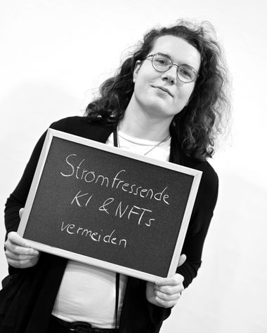 Eine Person aus Oldenburg zeigt ein Schild auf dem steht „Stromfressende KI und NFTs vermeiden“ Foto: Jörg Hemmen