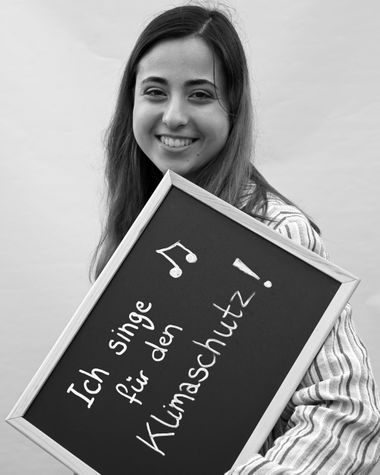 Eine Person aus Oldenburg zeigt ein Schild auf dem steht „Ich singe für den Klimaschutz!“ Foto: Jörg Hemmen