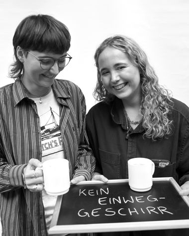 Zwei Personen aus Oldenburg zeigen ein Schild auf dem steht „Kein Einweggeschirr“ Foto: Jörg Hemmen