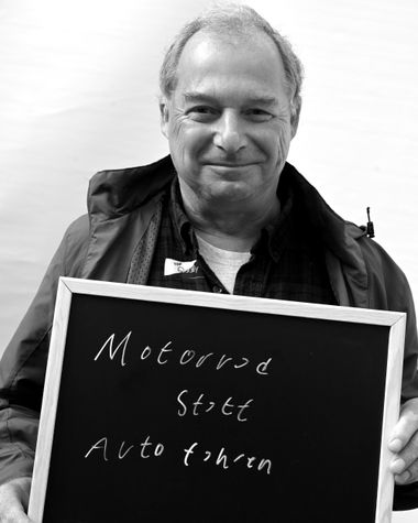 Eine Person aus Oldenburg zeigt ein Schild auf dem steht „Motorrad statt Auto fahren“ Foto: Jörg Hemmen