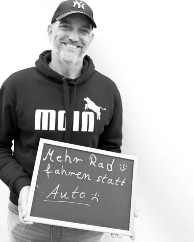 Eine Person aus Oldenburg zeigt ein Schild auf dem steht „Mehr Rad fahren statt Auto“ Foto: Jörg Hemmen