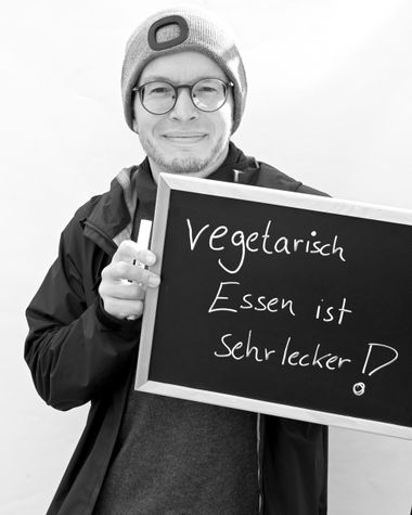 Eine Person aus Oldenburg zeigt ein Schild auf dem steht „vegetarisch Essen ist sehr lecker!“ Foto: Jörg Hemmen