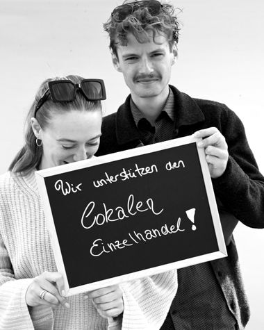 Zwei Personen aus Oldenburg zeigen ein Schild auf dem steht „Wir unterstützen den lokalen Einzelhandel!“ Foto: Jörg Hemmen