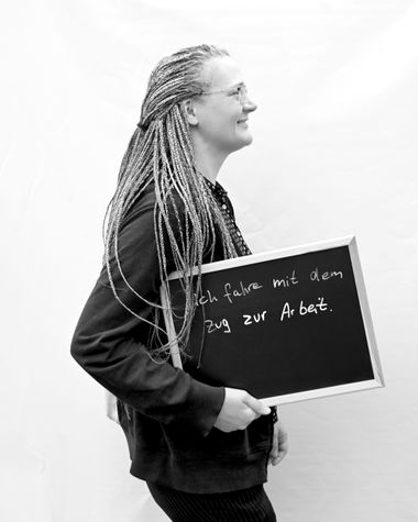 Eine Person aus Oldenburg zeigt ein Schild auf dem steht „Ich fahre mit dem Zug zur Arbeit.“ Foto: Jörg Hemmen