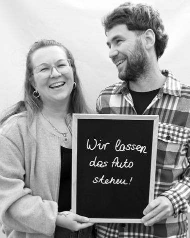 Eine Person aus Oldenburg zeigt ein Schild auf dem steht „Wir lassen das Auto stehen!“ Foto: Jörg Hemmen