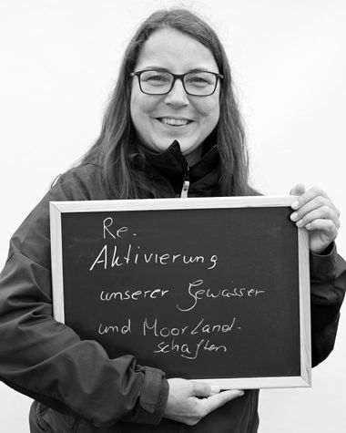 Eine Person aus Oldenburg zeigt ein Schild auf dem steht „Reaktivierung unserer Gewässer und Moorlandschaften“ Foto: Jörg Hemmen