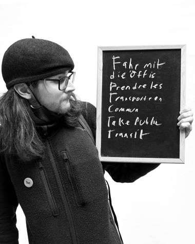 Eine Person aus Oldenburg zeigt ein Schild auf dem steht „Fahr mit die Öffis“ Foto: Jörg Hemmen