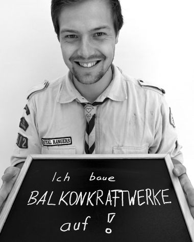 Eine Person aus Oldenburg zeigt ein Schild auf dem steht: „Ich baue Balkonkraftwerke auf!“ Foto: Jörg Hemmen