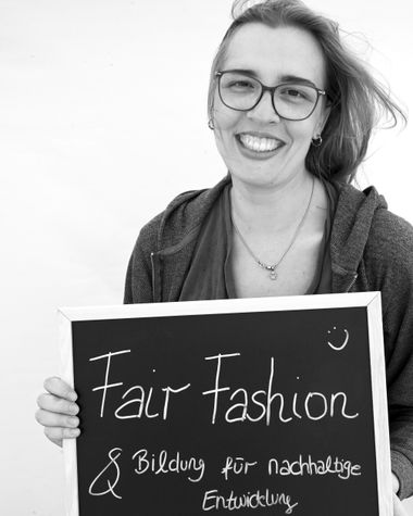 Eine Person aus Oldenburg zeigt ein Schild auf dem steht „Fairfashion und Bildung für nachhaltige Entwicklung“ Foto: Jörg Hemmen