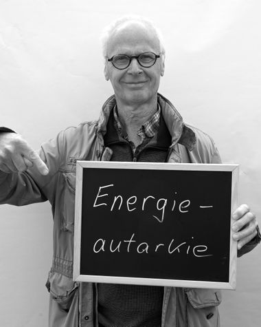 Eine Person aus Oldenburg zeigt ein Schild auf dem steht „Energieautarkie“ Foto: Jörg Hemmen