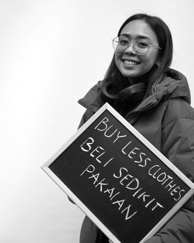 Eine Person aus Oldenburg zeigt ein Schild auf dem steht „Buy less clothes.“ Foto: Jörg Hemmen