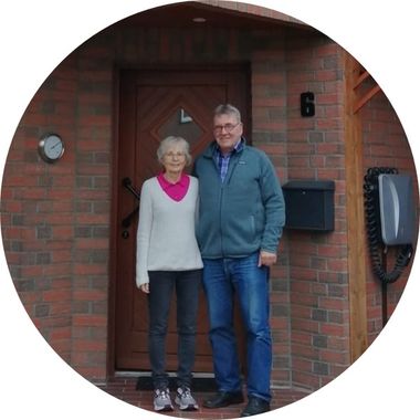 Zu sehen sind zwei Menschen, die vor ihrer Haustür stehen. Foto: privat