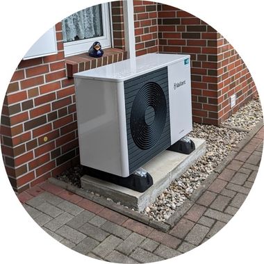 Zu sehen ist eine Wärmepumpe, die vor einem Altbau auf einem Kiesgrund steht. Foto: privat