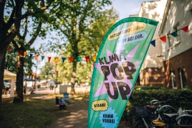 Flagge draußen vor dem KLIMA POP-UP während der Aktionswochen