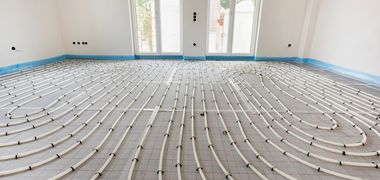 Zu sehen ist eine Fußbodenbodenheizung in einem hellen Raum. Foto: Wolfilser/Adobe Stock