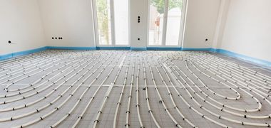 Zu sehen ist eine Fußbodenbodenheizung in einem hellen Raum. Foto: Wolfilser/Adobe Stock