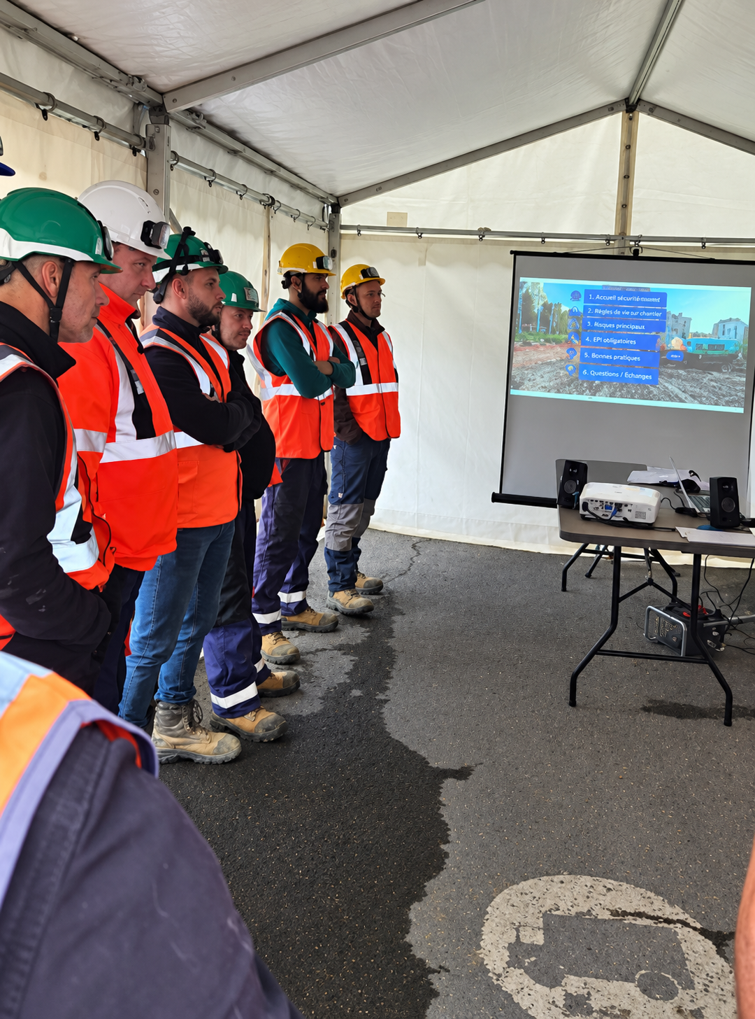 Construction crew members watch the projected screen during a workshop